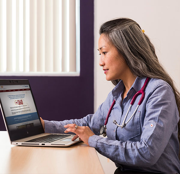 Decorative image of a physician looking at the MCC 360 webpages on her laptop